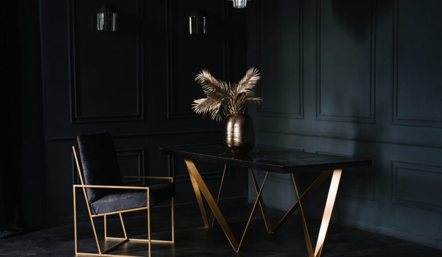 Black and gold chair and table. Living room is dimly lit, giving it a mysterious and elegant atmosphere
